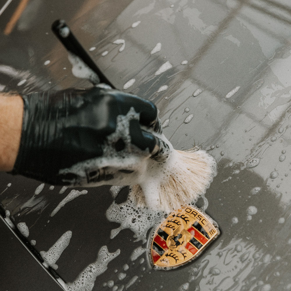 Detail Bursh in actie op motorkap embleem